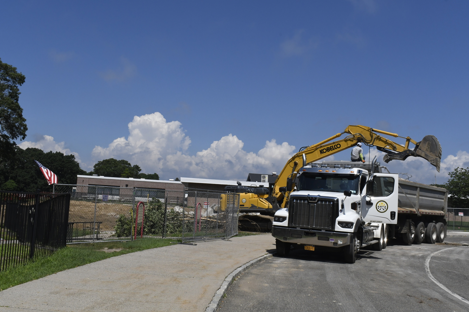 A crane works on demoing portable classrooms at Westhampton Beach Elementary School on July 16. The work had nothing to do with the varsity baseball field located behind the elementary school.  DREW BUDD