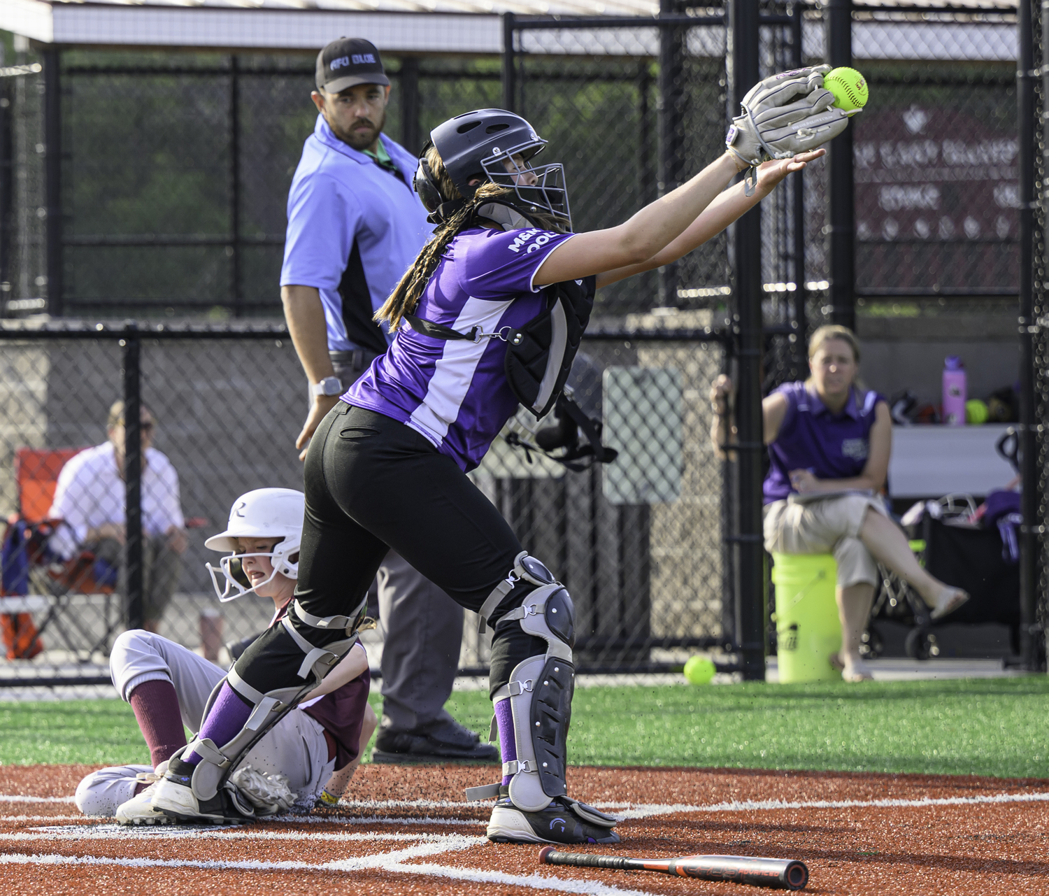 Aryanna Kappers stretches out to catch the ball to try and get an East Hampton base runner out at the plate.  MARIANNE BARNETT