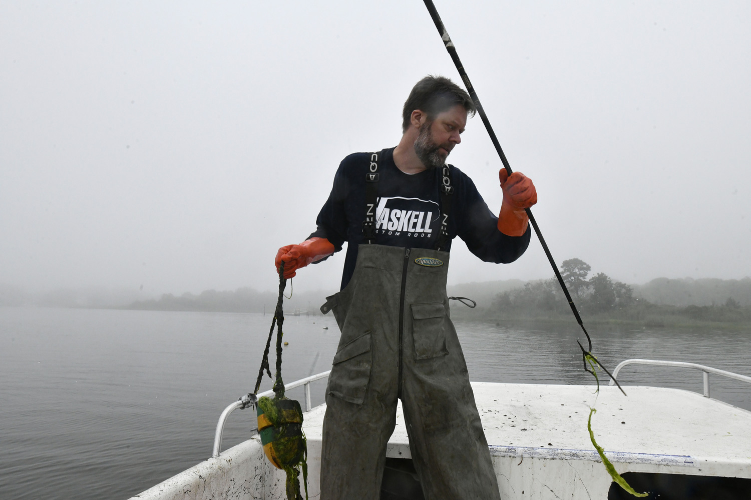 Captain Peter Haskell checks crab pots on Weesuck Creek on a foggy, misty day.  DANA SHAW
