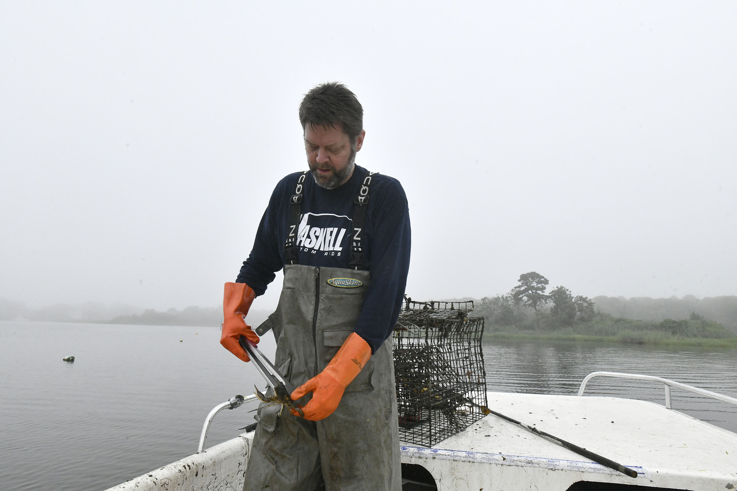 Captain Peter Haskell checks crab pots on Weesuck Creek on a foggy, misty day.  DANA SHAW