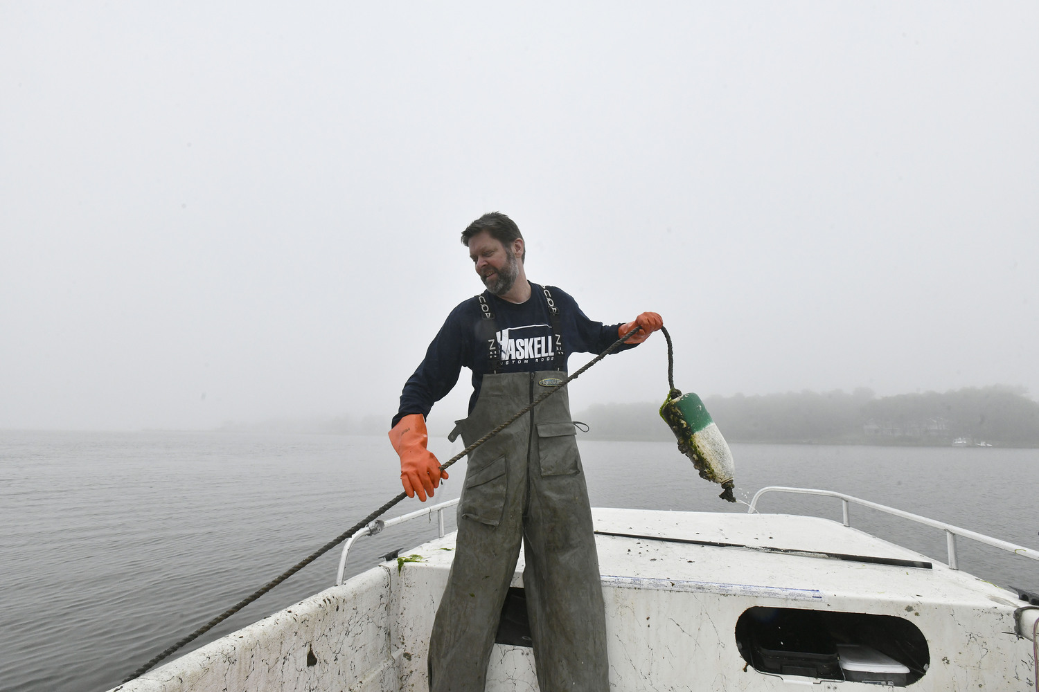 Captain Peter Haskell checks crab pots on Weesuck Creek on a foggy, misty day.  DANA SHAW