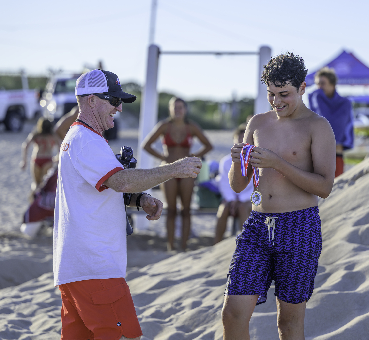 East Hampton Town Chief Lifeguard and HLA President John Ryan Jr. hands out an award to a finisher.  MARIANNE BARNETT