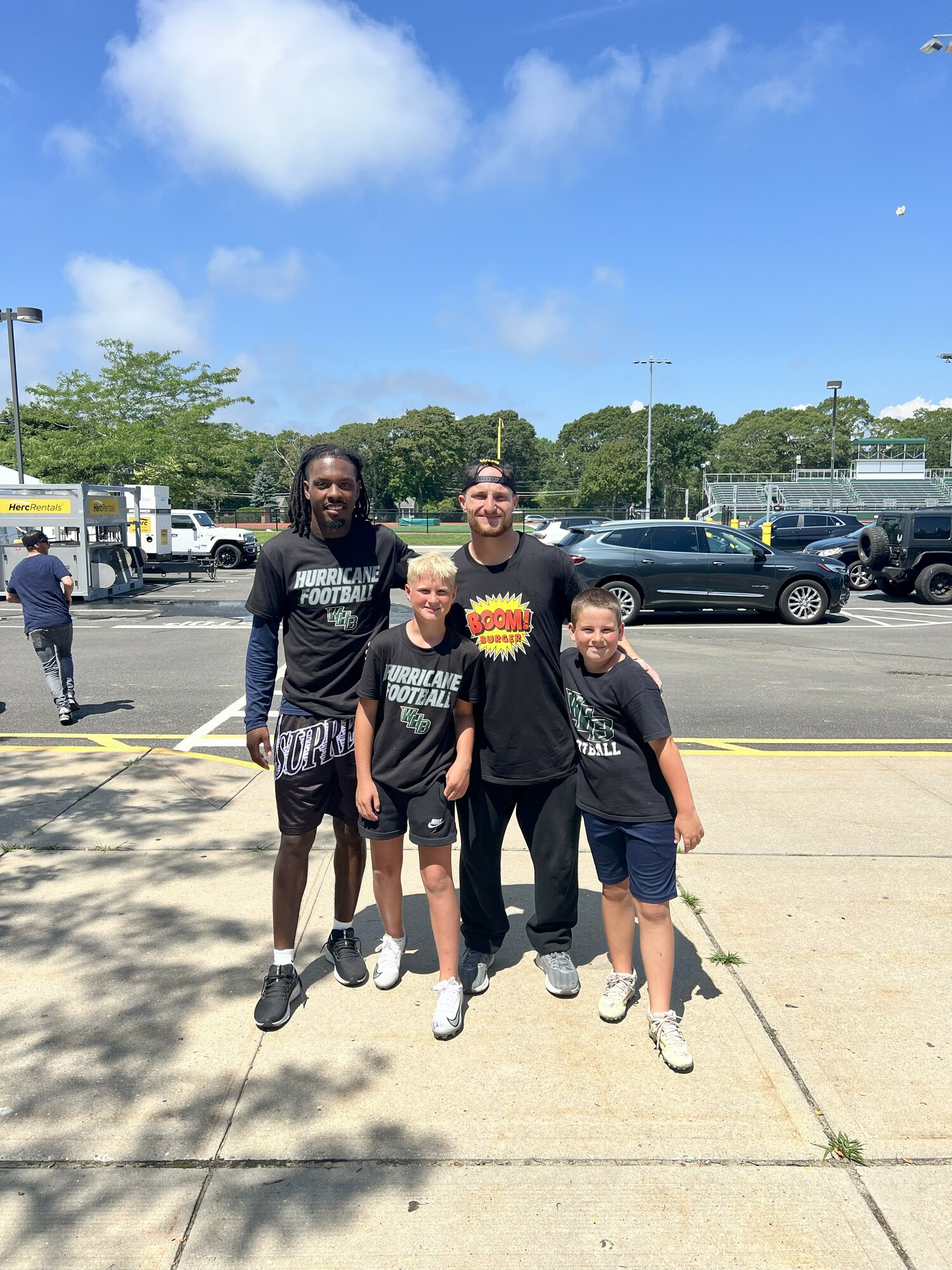 Pro football players D.J. James and Dylan Laube with a pair of campers.   COURTESY MARK JOHNSON