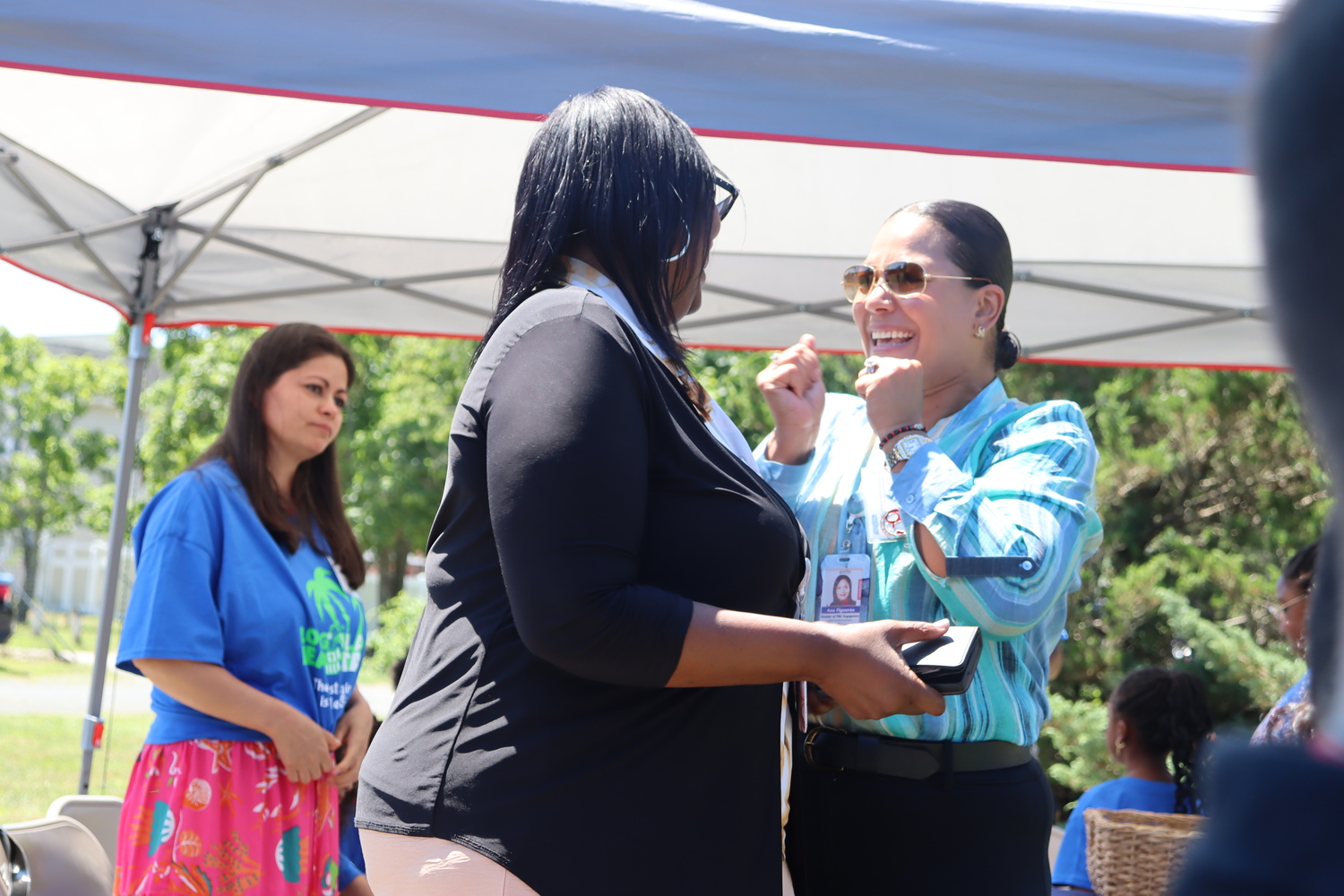 Long Island Head Start's Director of Program Operations Annette Harris, left, and Associate Director of Parent/Community Engagement Ana Figueroa, right, react after New York State Assemblyman Tommy John Schiavoni announced that the state pledged $2.25 million in funding toward the overall $4 million cost of building a new 