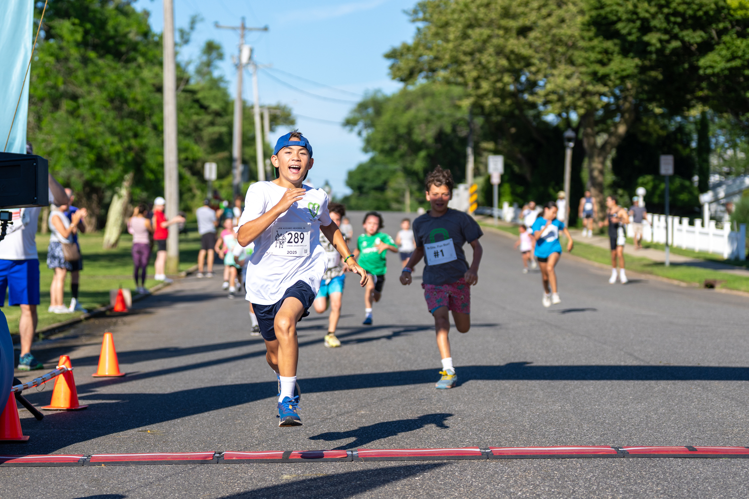 Charlie Sparke of Vernon, Connecticut, leads the pack of young runners across the finish line during the 