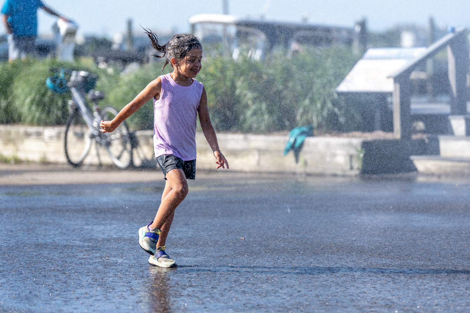 A youngster appreciates the shower provided by the Westhampton Beach Fire Department.  RON ESPOSITO