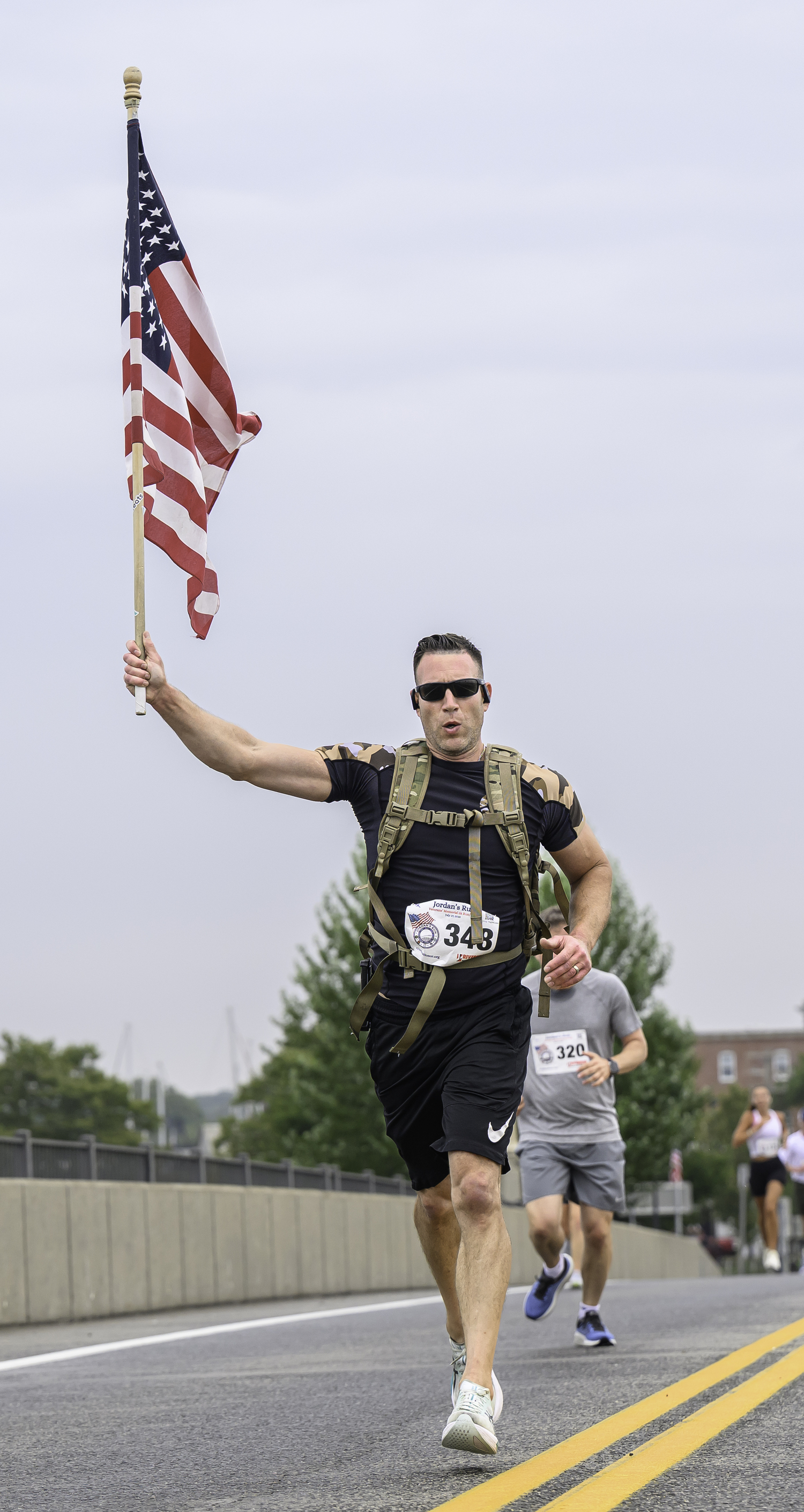 Greg Waxman of Malverne carries the flag over the Lance Cpl. Jordan Haerter Memorial Bridge.  MARIANNE BARNETT