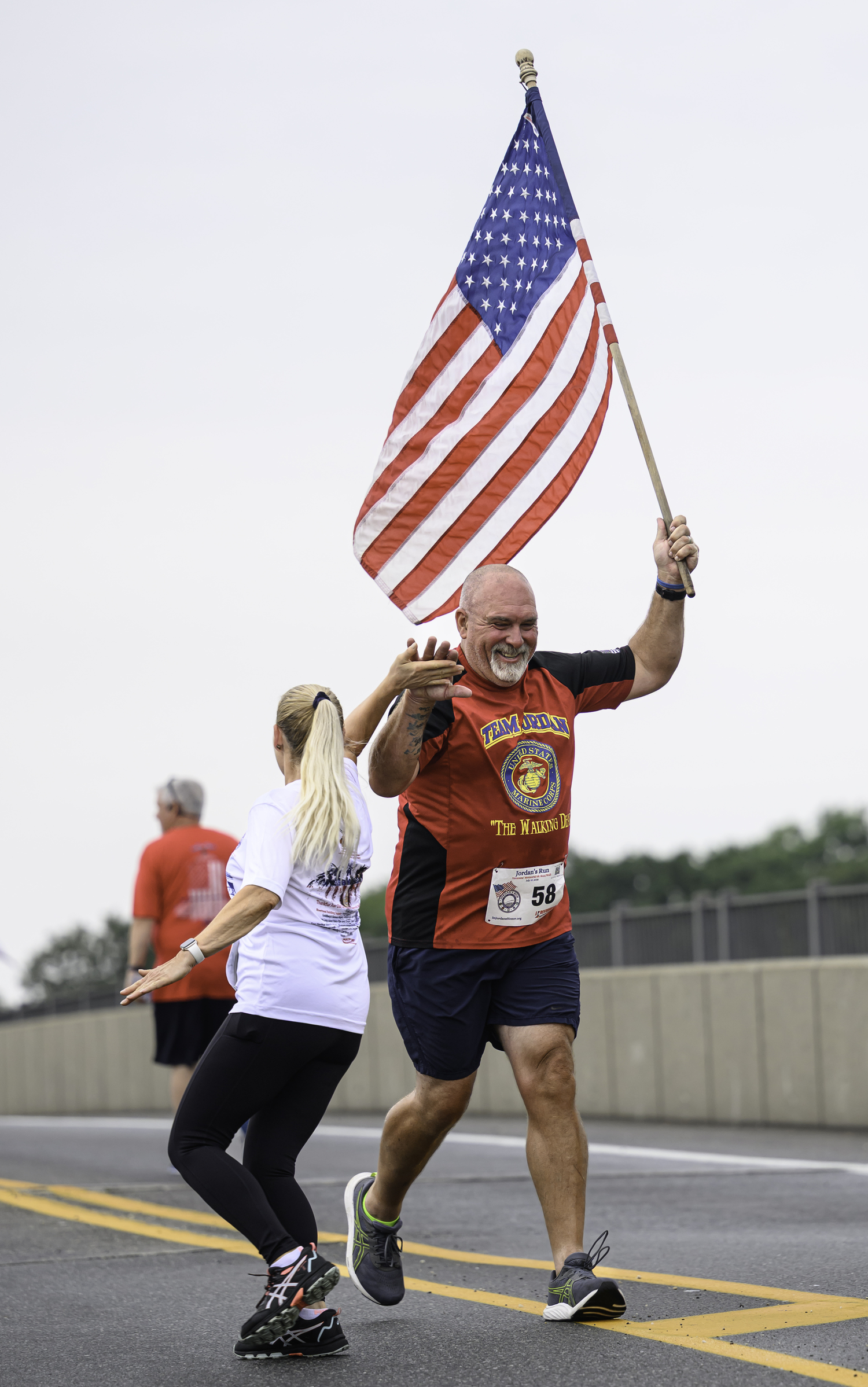Michael Davis receives a high-five from a fellow runner.  MARIANNE BARNETT