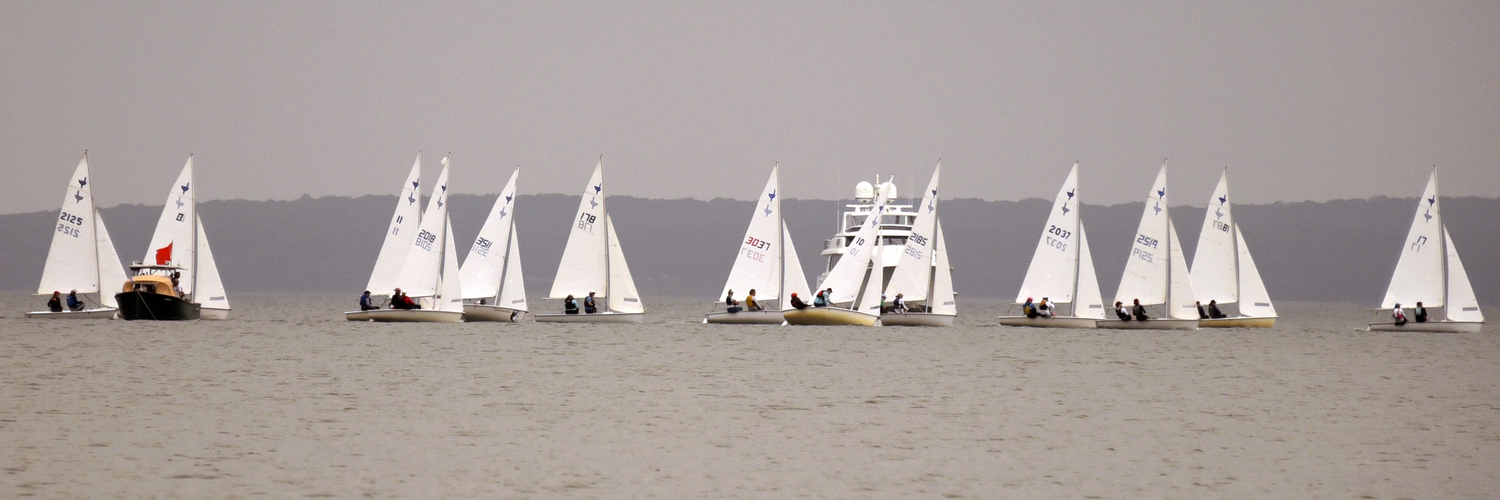 With the red-flagged committee boat anchoring the left side, a brilliant start is spread across the horizon. First place Venetia Satow is third from right; second place Charlotte LeClue is fourth from right.  MICHAEL MELLA