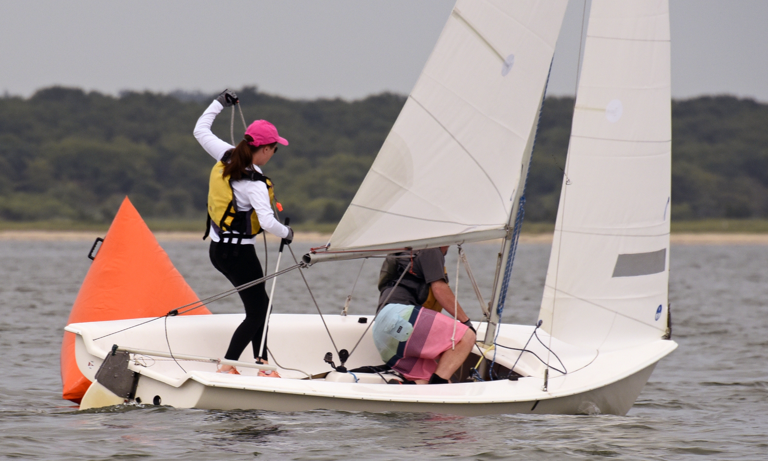 As second place Charlotte LeClue deftly demonstrates, the skipper has two jobs: steering the boat and “manning” the mainsheet, while her brother Josh fine-tunes the jibsheet.  MICHAEL MELLA