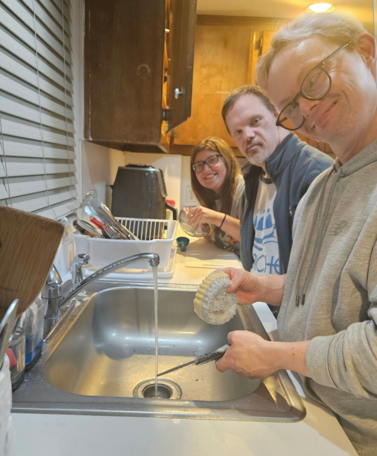 L'Arche Long Island residents, from left, Joanna P., John Paul G. and Bryan Salton wash the dishes. COURTESY KATHLEEN COLON
