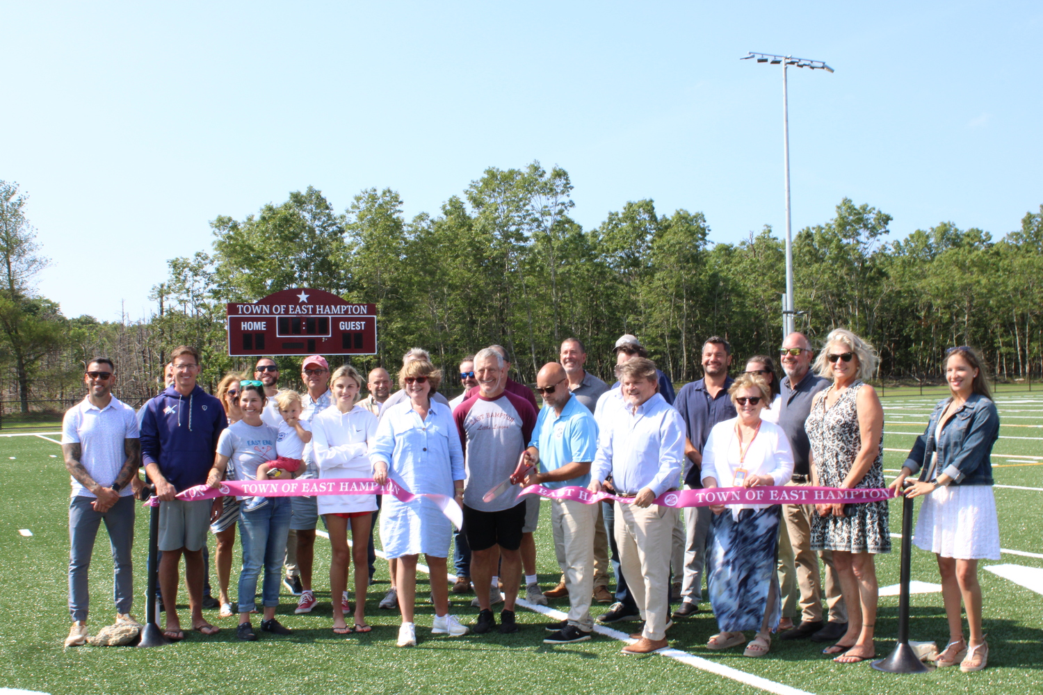 Members of the East Hampton Town Board, New York State Assemblyman Tommy John Schiavoni, Suffolk County Legislator Ann Welker and others cut the ribbon for the multi-use field on Stephen Hands Path on Thursday, July 24. JACK MOTZ