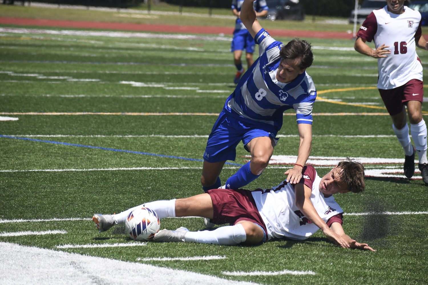 Fordham freshman Nick Mesquita cleanly slides tackles Seton Hall freshman Valentino Solari to jar the ball loose.  DREW BUDD