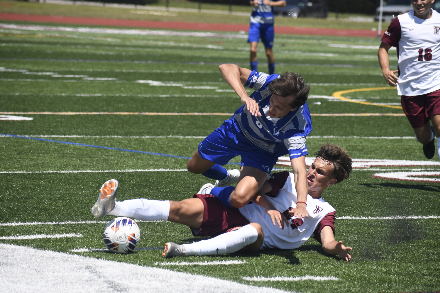 Fordham freshman Nick Mesquita cleanly slides tackles Seton Hall freshman Valentino Solari to jar the ball loose.  DREW BUDD