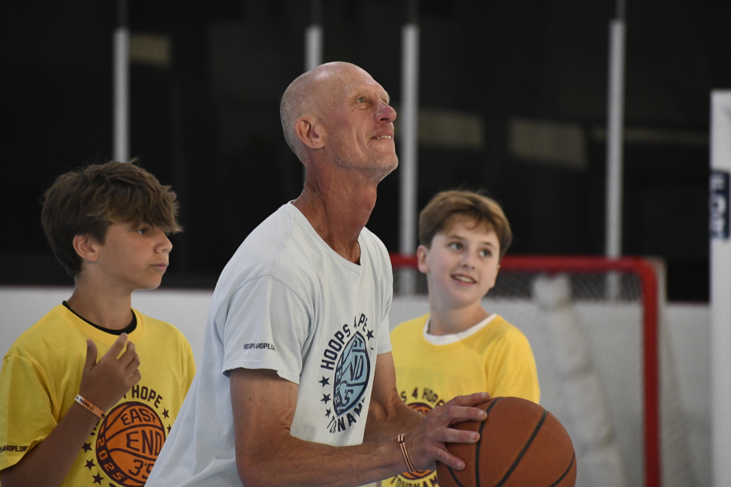 Cofounder of Hoops 4 Hope Mark Crandall partakes with a few young players.  DREW BUDD