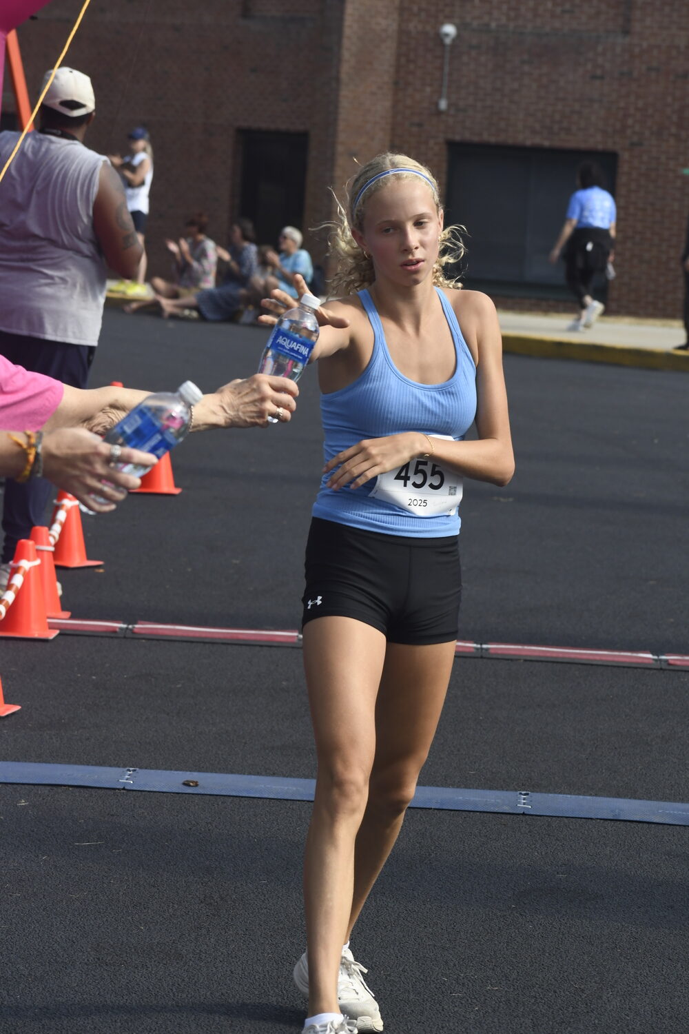 Fairfax Walker takes a bottle of water after finishing second among females.  DREW BUDD