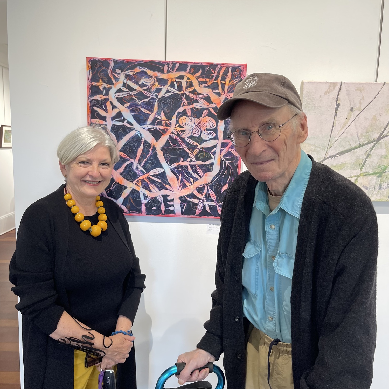Curator Donna Corvi with artist Roy Nicholson and his work 