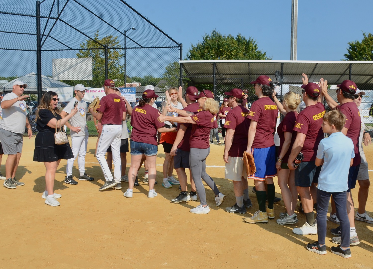 The Artists and Writers shake hands after the Writers ended their three-game losing streak with a 9-6 victory.  KYRIL BROMLEY