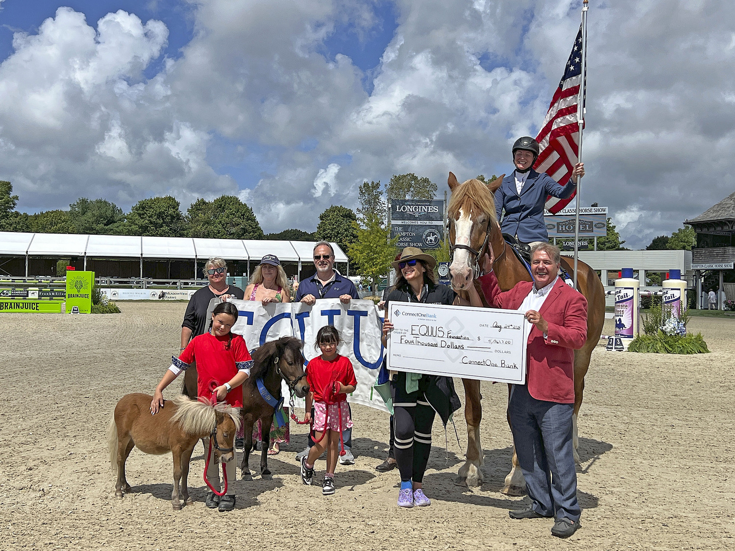 Seamus Doyle, far right, presented a donation from Connect One Bank to the EQUUS Foundation at opening day ceremonies at the Hampton Classic Horse Show on Sunday.  DANA SHAW