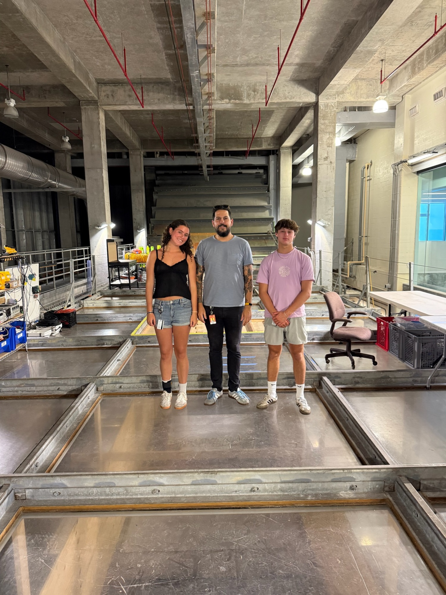 Ella Menu with mentor Dr. Milan Curcic and Cole Dunchick in the University of Miami's Alfred C. Glassell, Jr. SUSTAIN (SUrge-STructure-Atmosphere-INteraction) Lab, standing on top of a 75-foot long, 38,000 gallon wind-wave tank that scientists use to simulate tropical storm, hurricane and storm surge impacts. The students spent part of their summer working closely with Dr. Curcic in the lab as a part of their summer science research project. John Dunchick photo