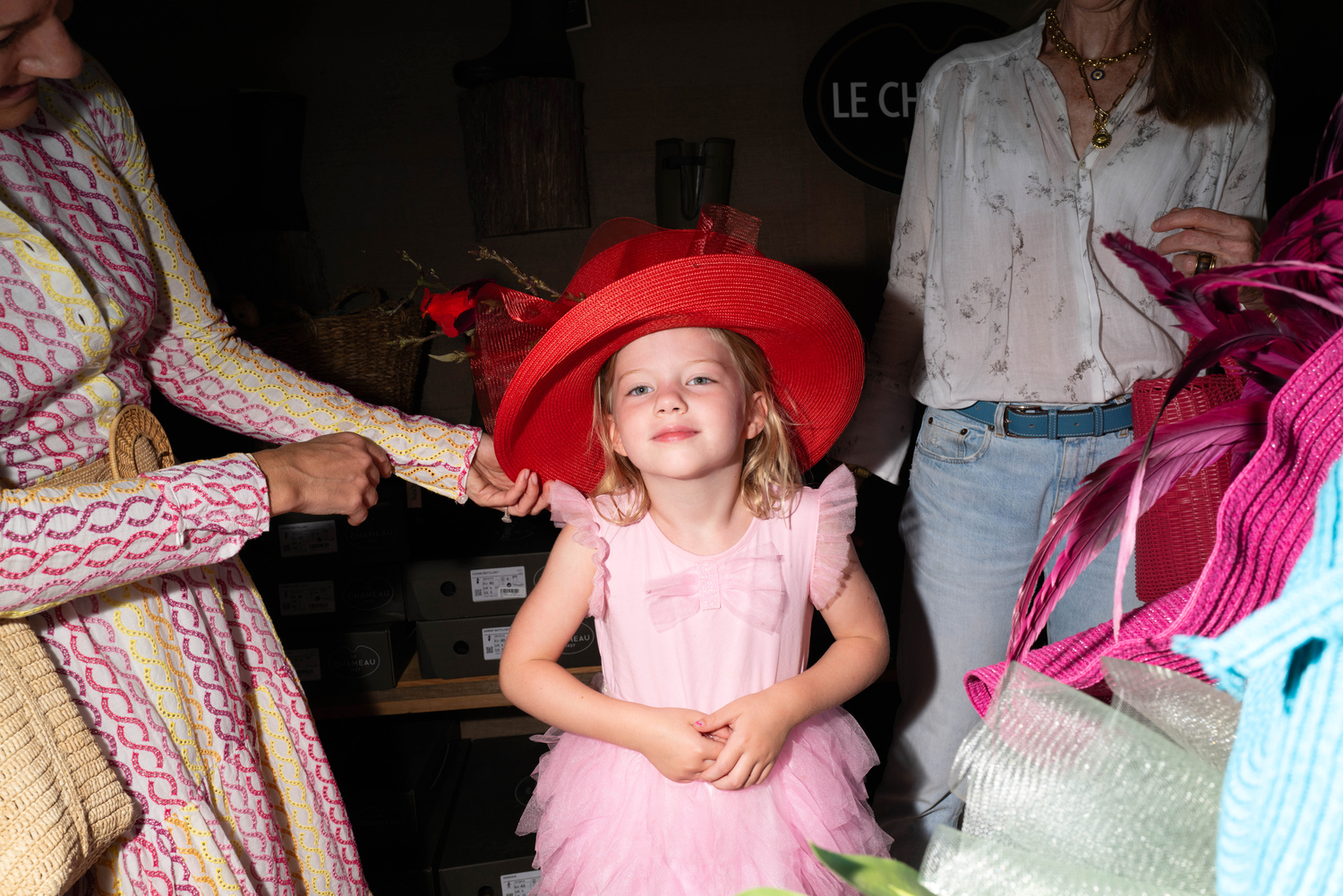 Emmy Graham tries on hats at the Marder's tent.  LORI HAWKINS