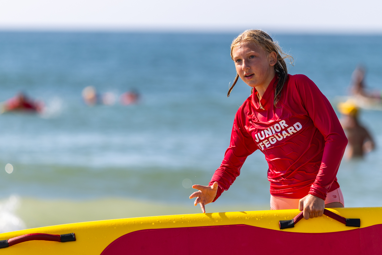 A junior lifeguard lifts a rescue board.  RON ESPOSITO