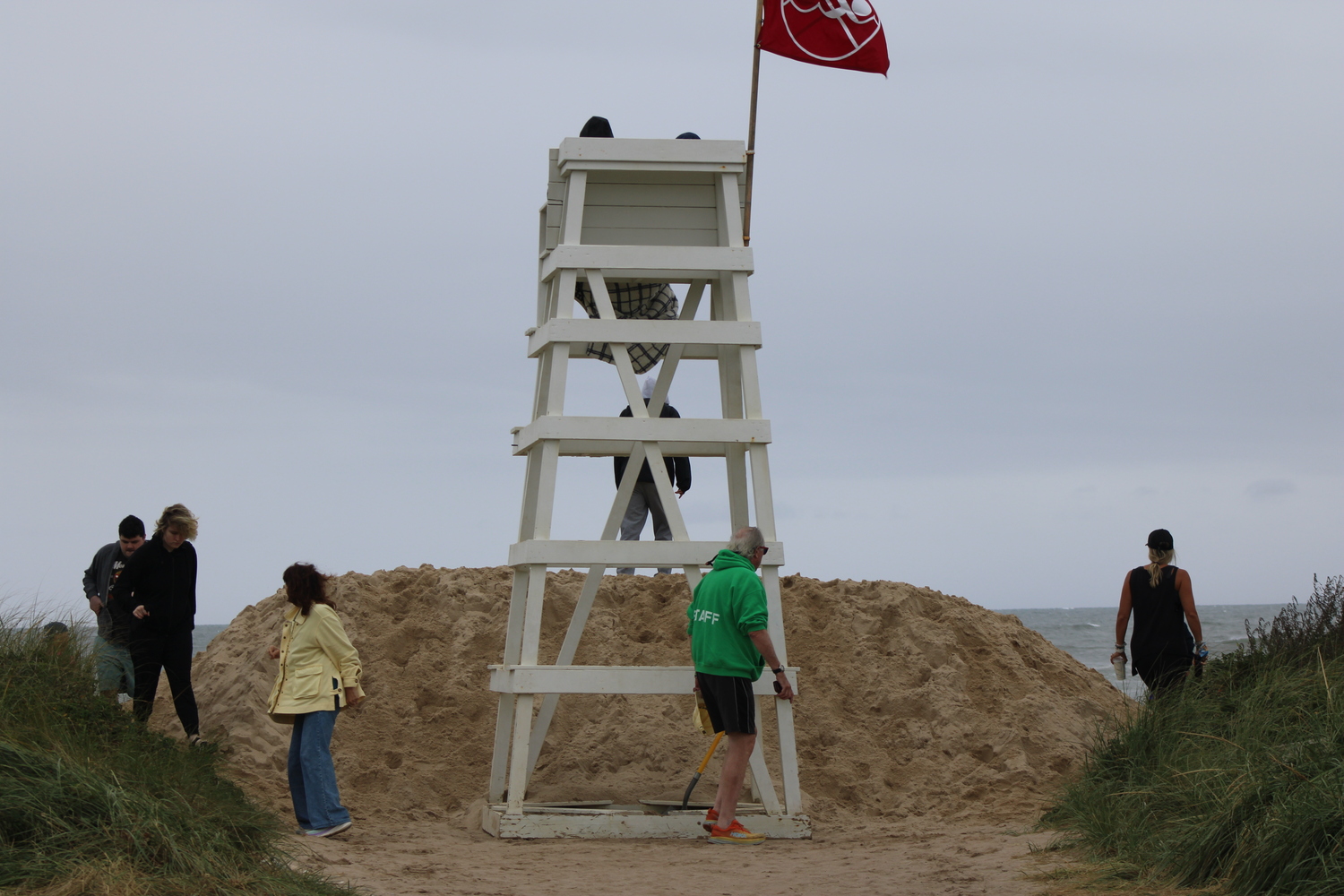 Officials piled up a sand barrier at the entrance of Ditch Plains Beach on Wednesday, August 20, in preparation for Hurricane Erin. Around the lifeguard stand, curious visitors gathered. JACK MOTZ
