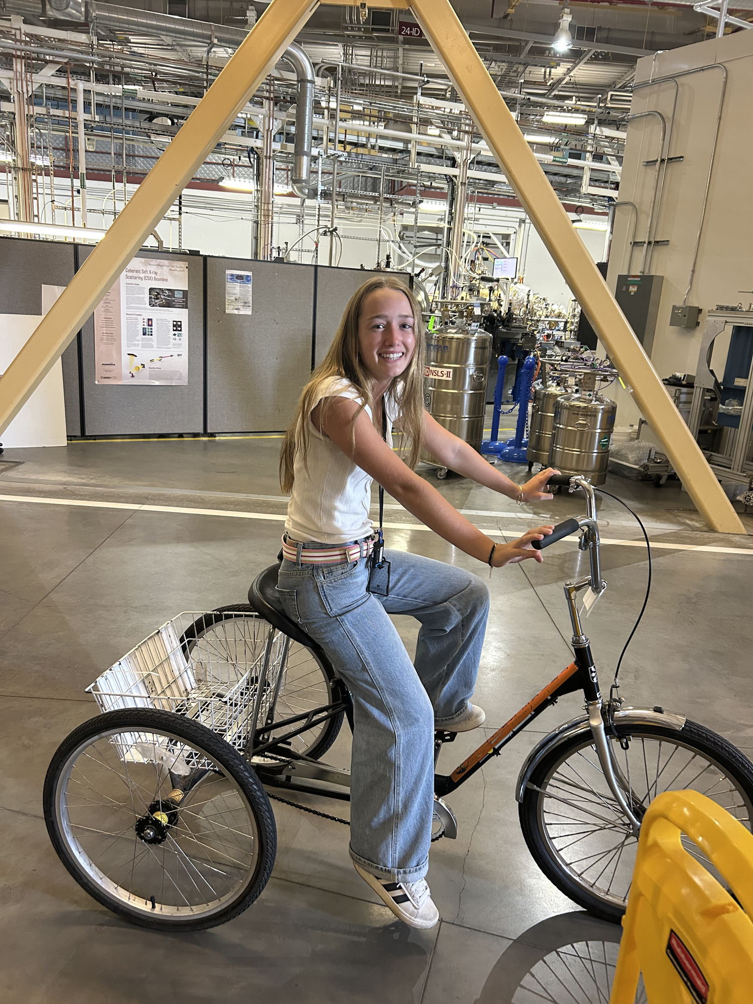 Chelsea Fromm, riding the tricycle at Brookhaven Lab, which allows students to get around on the giant XPD beamline.