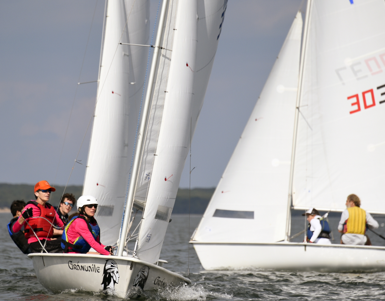 Port tack skipper Derrick Galen with Amelia Steelman “manning” the jib, camera right, about to follow the two JY’s on the left to the windward mark. MICHAEL MELLA