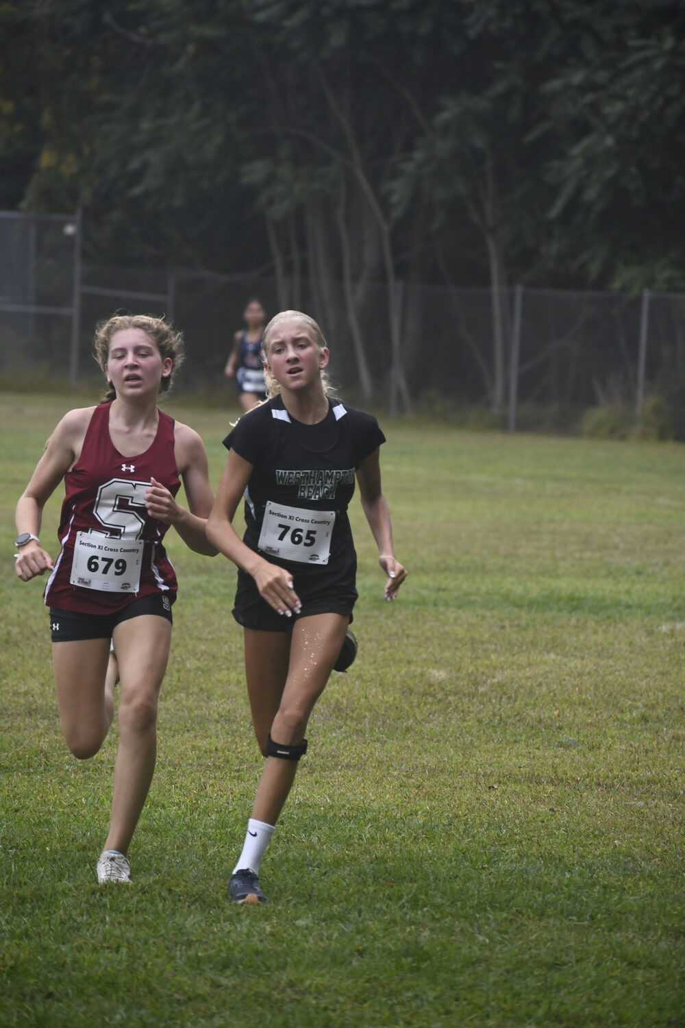 Southampton eighth-grader Zoey Ruiz tries to fend off Westhampton Beach freshman Lilly Guja in Saturday's freshman race.  DREW BUDD