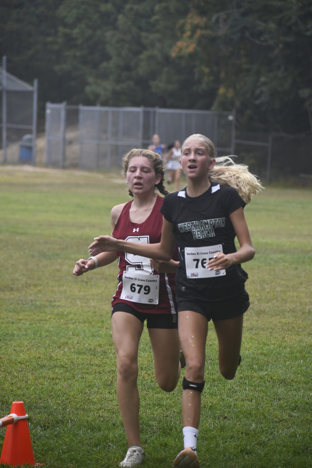 Lilly Guja surpasses Southampton eighth-grader Zoey Ruiz at the finish line to finish second in the girls freshman 1.5-mile race.  DREW BUDD