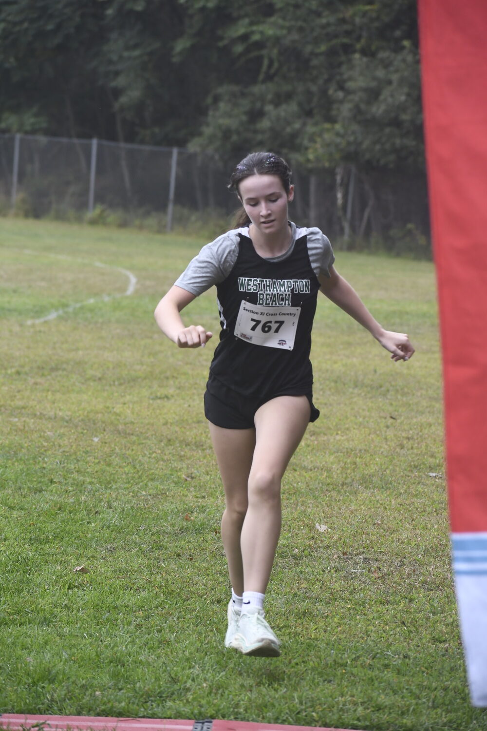Catherine Robesch crosses the finish line in the girls freshman 1.5-mile race.   DREW BUDD