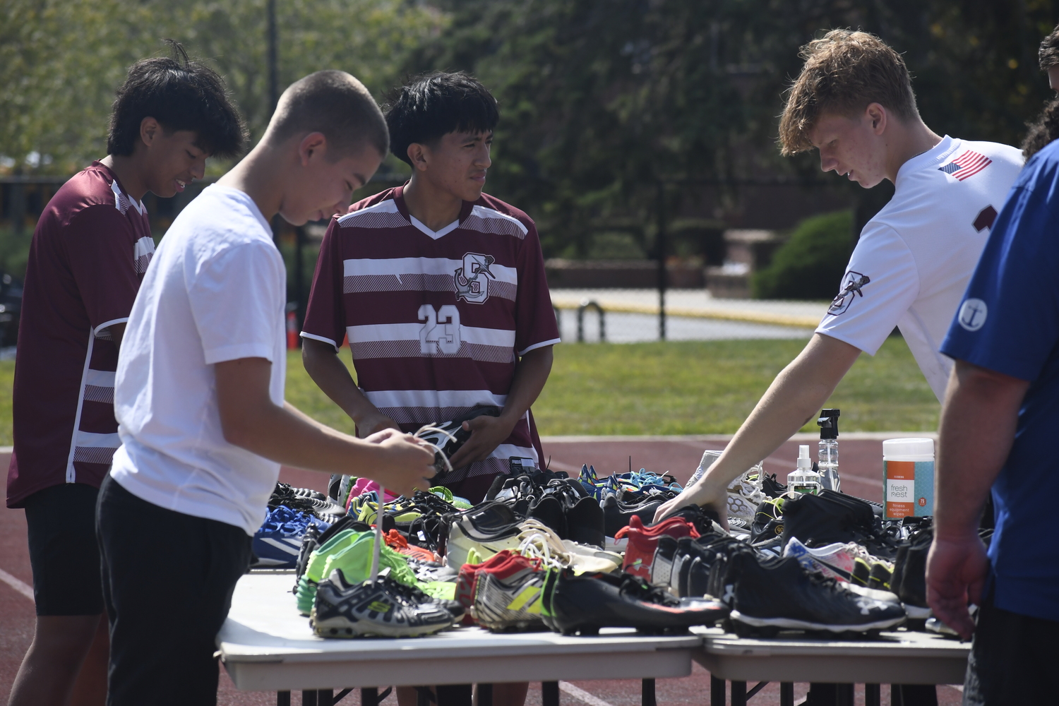 Members of the Southampton boys soccer team help clean gently used gear that was being resold on September 13 to help fund the district's unified soccer program.  DREW BUDD