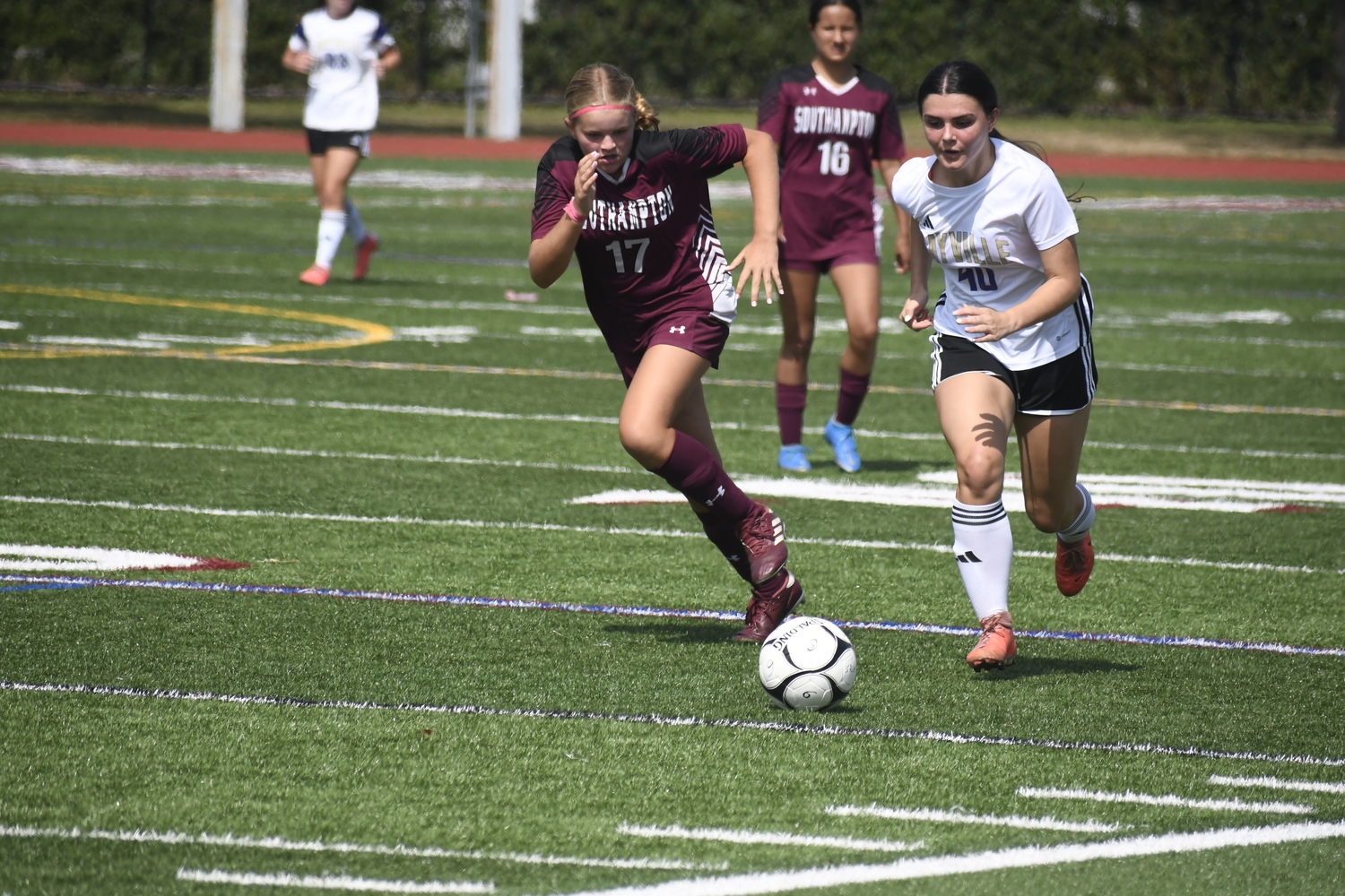 Southampton eighth-grader Peyton Hull keeps up with Sayville junior Riley Dolan.  DREW BUDD