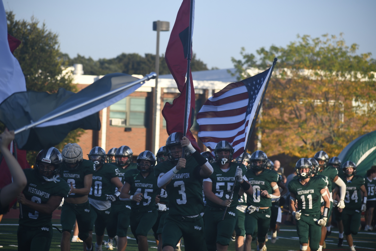 Senior Derrick Hansen leads the Hurricanes onto the field to get their game with crosstown rival Eastport-South Manor underway.  DREW BUDD