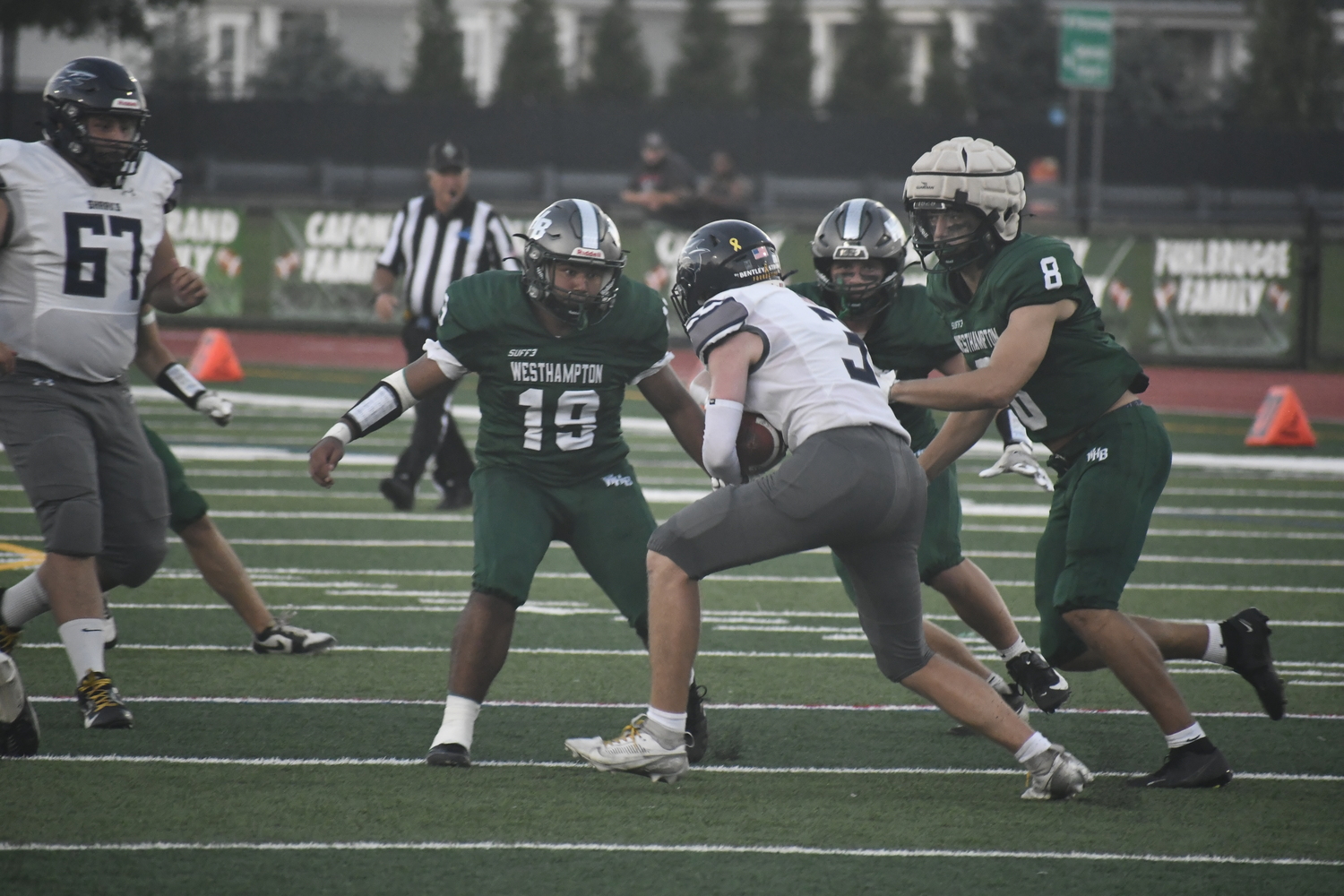 A trio of Hurricanes, led by senior Miguel Garcia (19), get to ESM's Zach Alfonzo on a kickoff return.  DREW BUDD