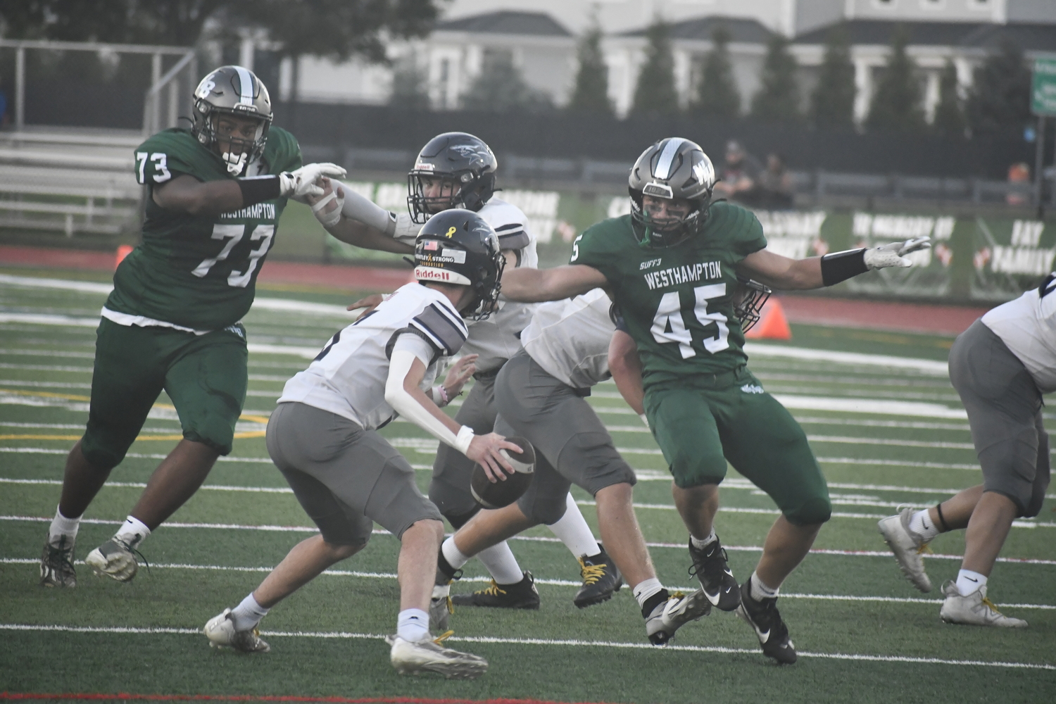 Westhampton Beach juniors Jaedyn Cobb, left, and Andrew Lewis quickly descend on ESM quarterback Matthew Beardsley for an eventual sack.  DREW BUDD