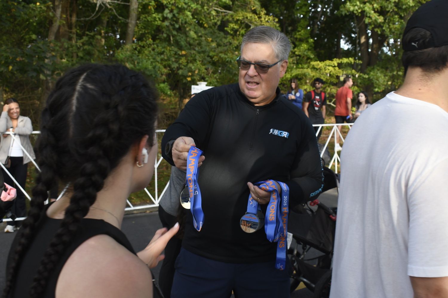 Volunteers hand out medals.  DREW BUDD