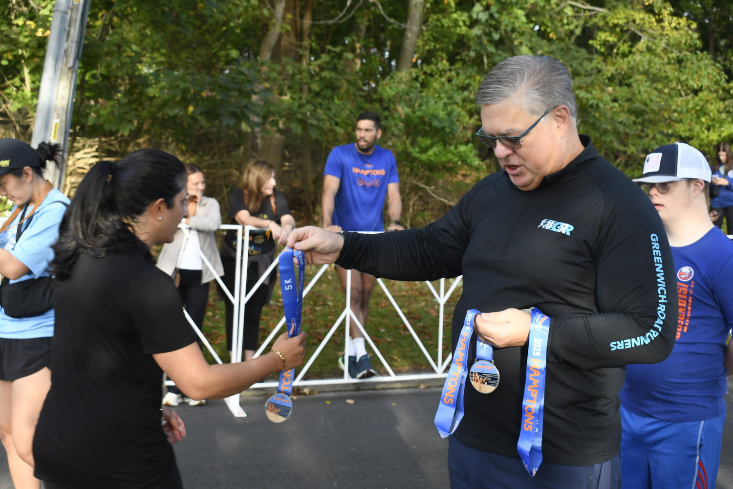 Volunteers hand out medals.  DREW BUDD
