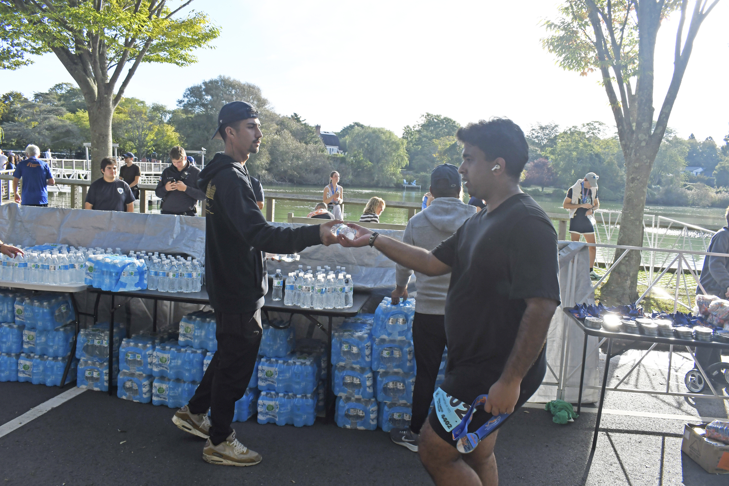 A volunteer hands out water to finishers.  DREW BUDD