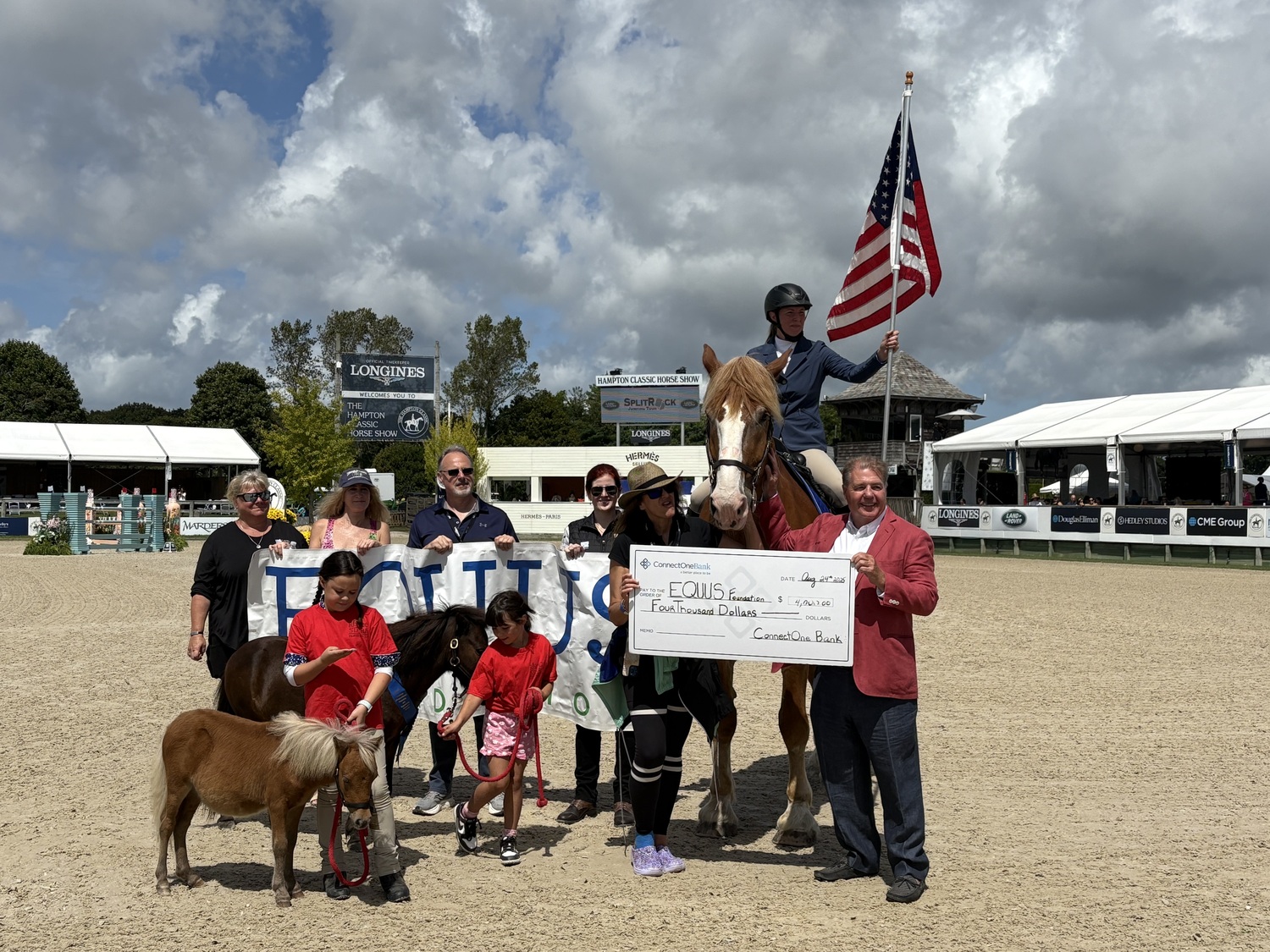 Seamus Doyle of ConnectOne Bank at the Hampton Classic last week presenting a $4,000 check to the Equus Foundation to assist their horse welfare efforts. COURTESTY CONNECTONE BANK