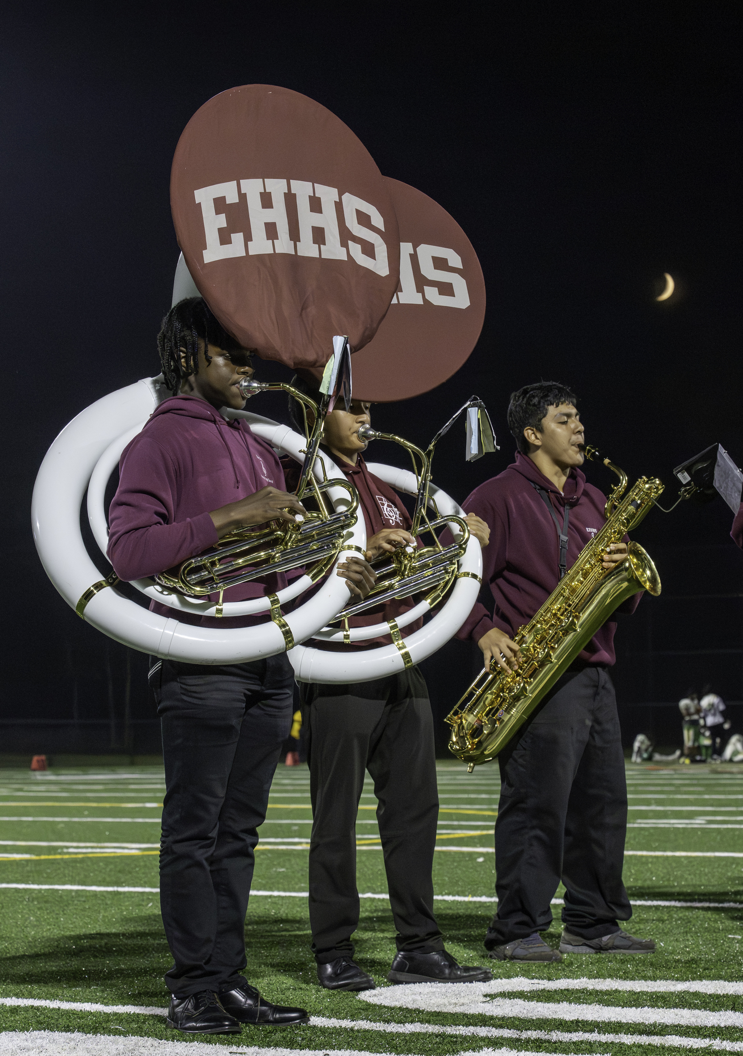 Members of East Hampton's marching band under a crescent moon Friday evening.  MARIANNE BARNETT