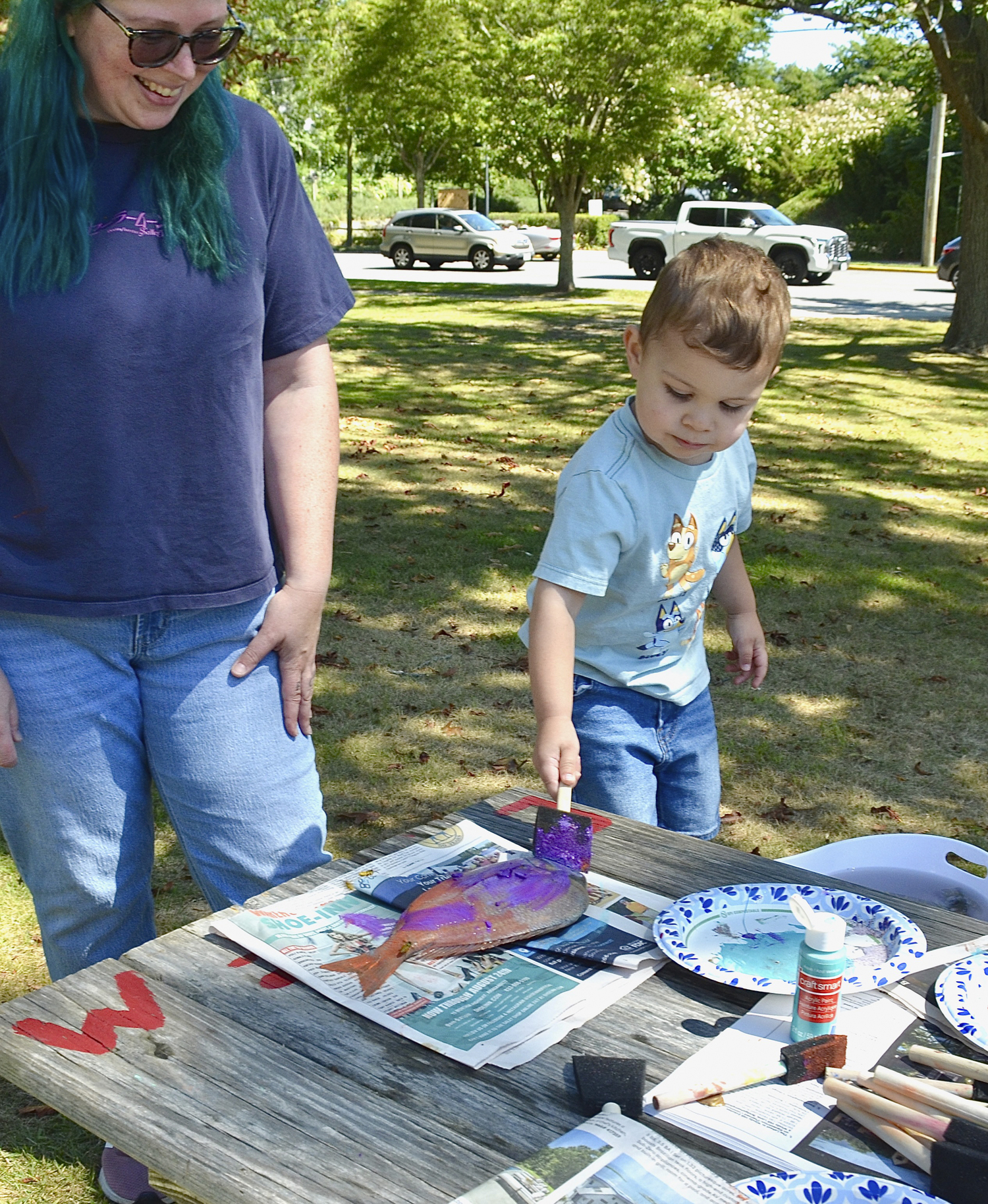 Kate Nicolai supervises as M.J. Fernandez paints a fish to create a fish print at the East Hampton Historical Farm Museum on Saturday.  KYRIL BROMLEY