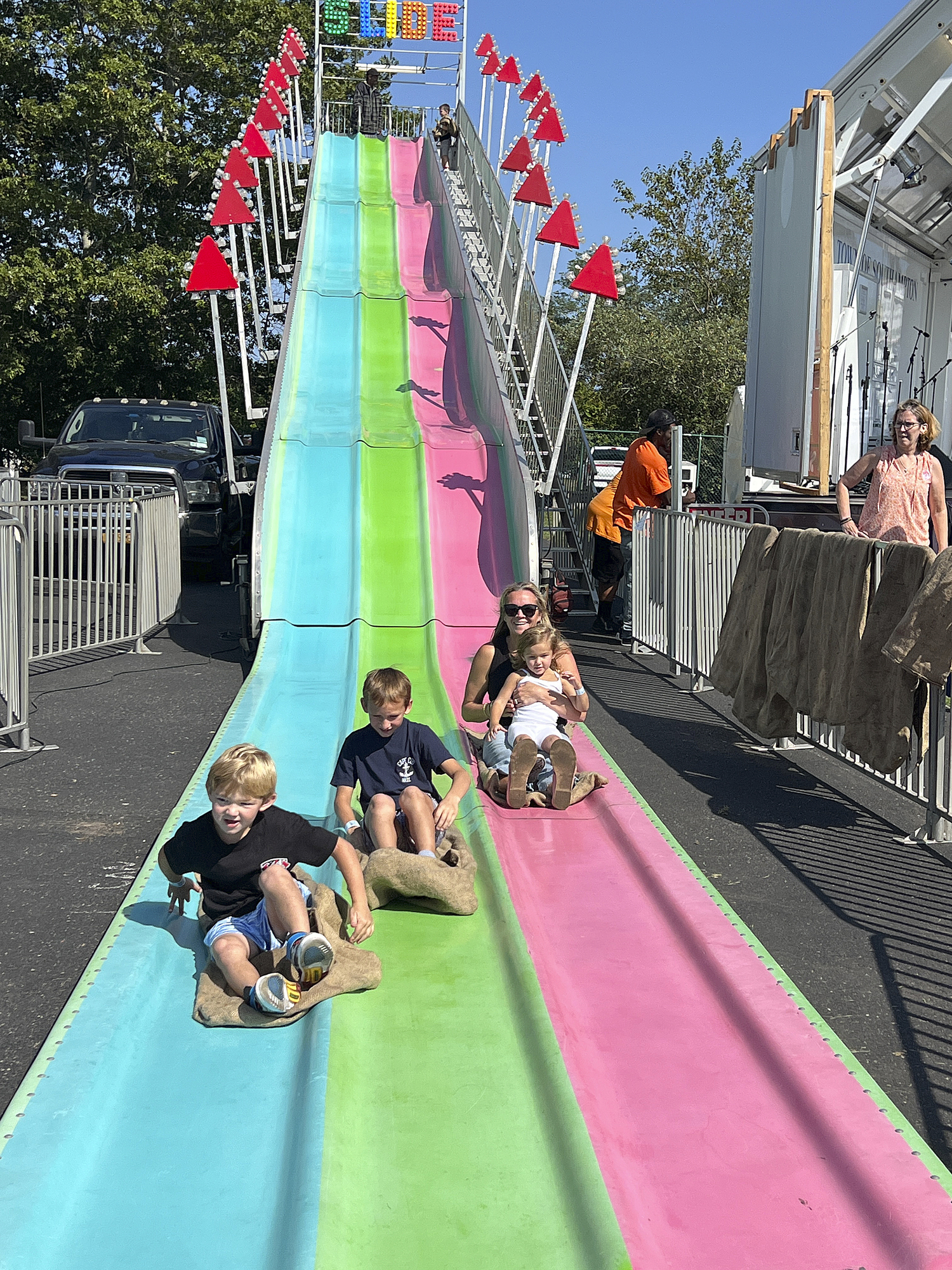 Kyle Mohrmann with Topher, Esme and Karrie Bandrowski on the slide at the Sangennaro Fest of the Hamptons on Saturday.