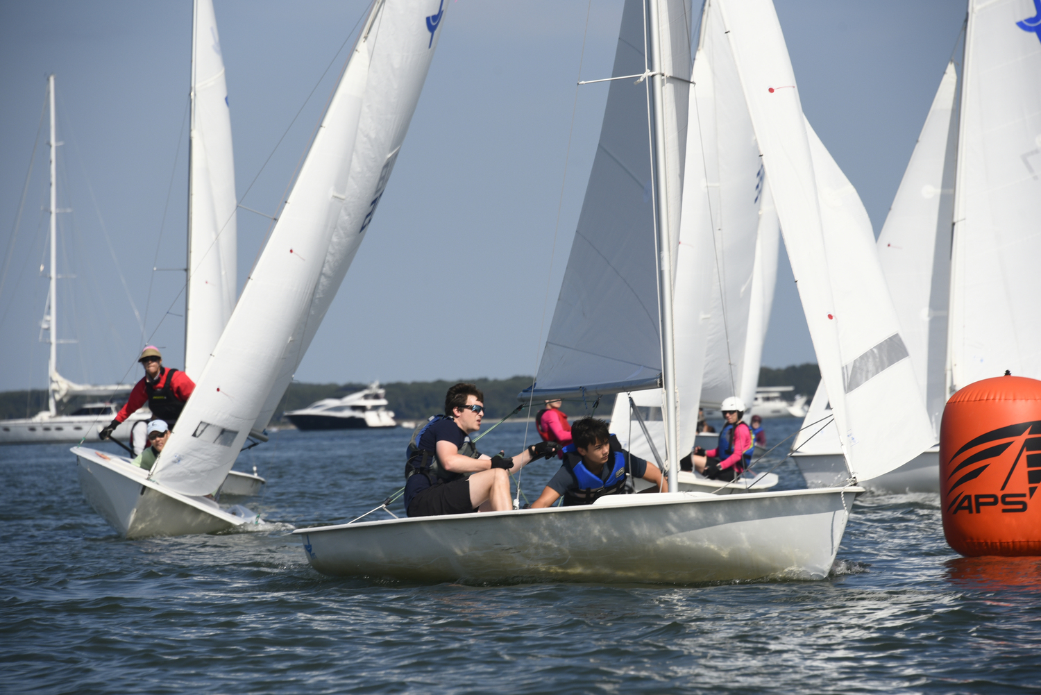 Sara Nightingale, left, and Stamford Yacht Club members Dylan Abel and Oliver Malstrom about to round the windward mark in fine fashion! Mark rounding’s demand laser beam focus and adherence to a specific set of rules regarding overlap within three boat lengths of the buoy.  MICHAEL MELLA