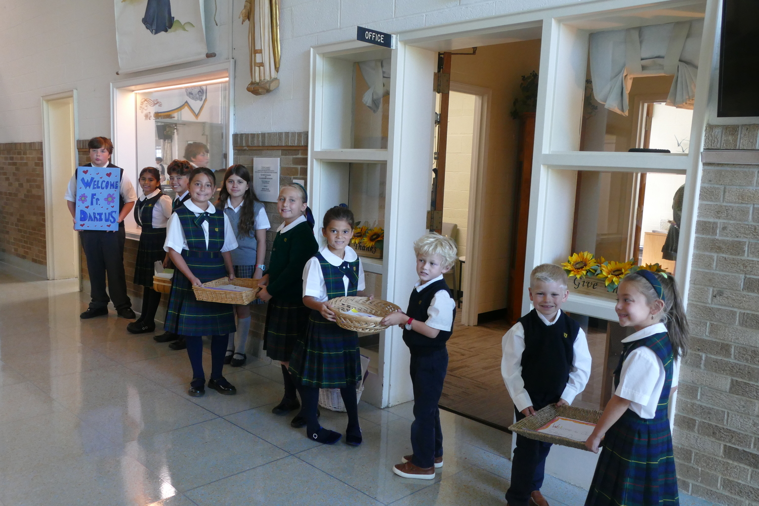 At the start of the new school year, representatives of each class at Our Lady of the Hamptons School presented gifts of welcome to the new administrator of Our Lady of Poland, Father Darius Koszyk. COURTESY OUR LADY OF THE HAMPTONS SCHOOL