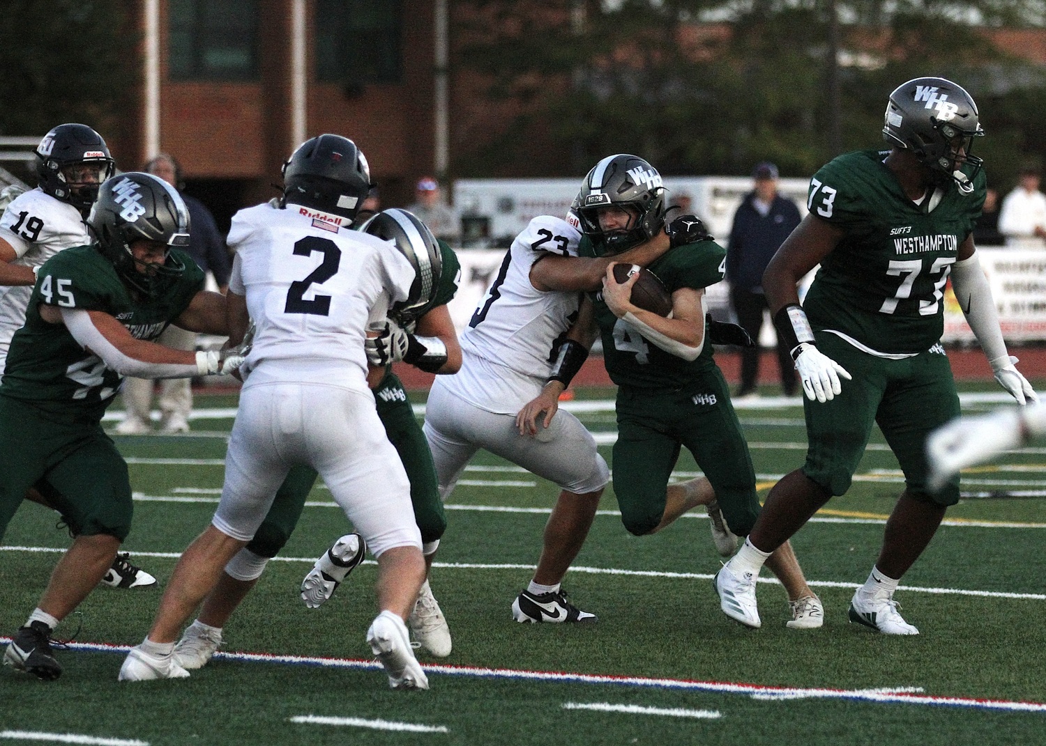 Junior quarterback Jake Calloway pushes through a Smithtown West lineman. DESIRÉE KEEGAN