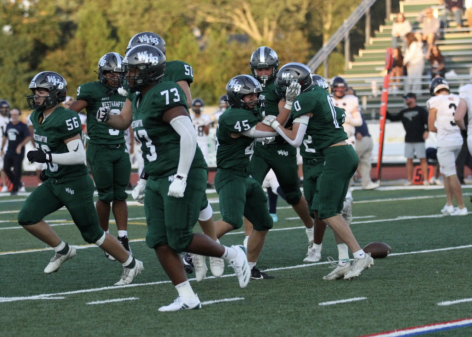 Senior wide receiver Nate LoGelfo (#0) is celebrated by his teammates after recovering the ball on a Smithtown West fumble. DESIRÉE KEEGAN