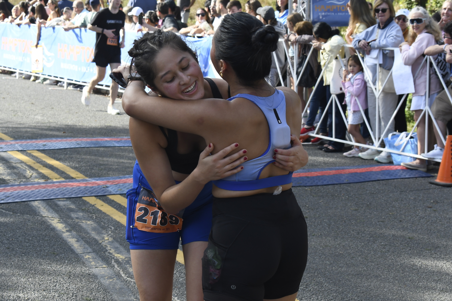 Friends embrace each other after finishing the half marathon. DREW BUDD