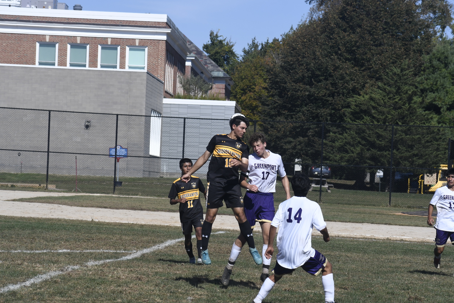 Bridgehampton senior co-captain Luis Penafiel goes up with a Greenport player for a header.  DREW BUDD